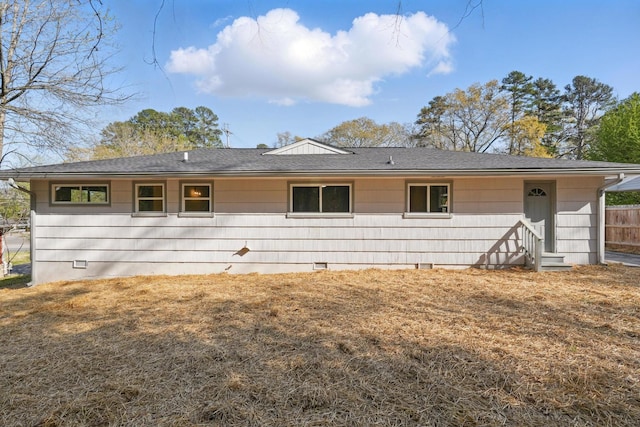 view of front of house with fence, roof with shingles, entry steps, and crawl space