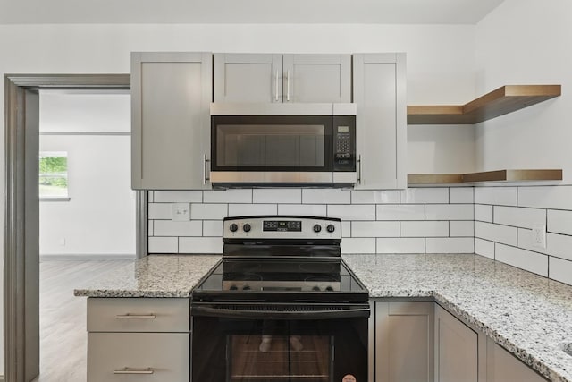 kitchen featuring gray cabinets, electric range oven, open shelves, and stainless steel microwave