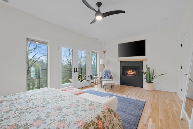 1122 Oman Dr, Brentwood, TN 37027 - bedroom with french doors, access to outside, wood finished floors, a glass covered fireplace, and a ceiling fan