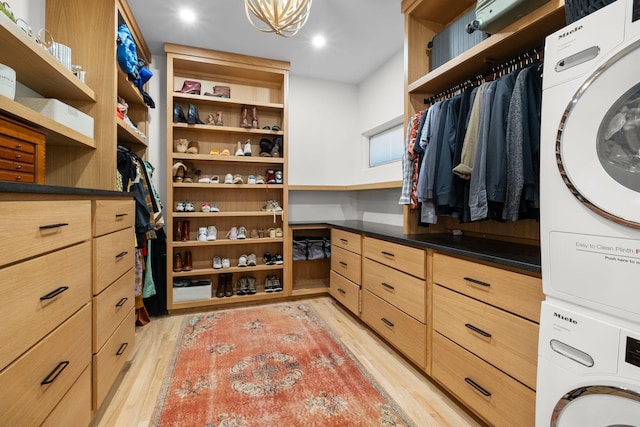 1122 Oman Dr, Brentwood, TN 37027 - walk in closet with estacked washer and dryer, light wood finished floors, and a chandelier