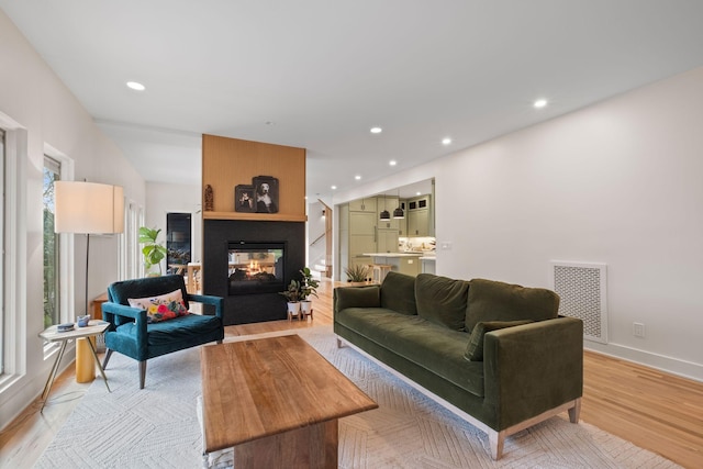 1122 Oman Dr, Brentwood, TN 37027 - living room featuring a multi sided fireplace, light wood-style floors, recessed lighting, and baseboards