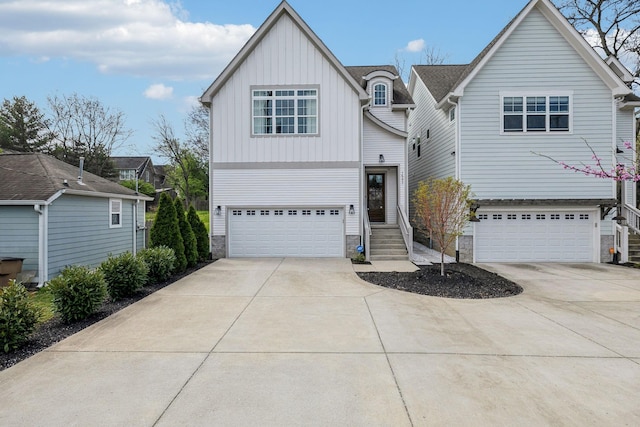 1547 Battlefield Dr, Nashville, TN 37215 - view of front facade featuring stone siding, board and batten siding, concrete driveway, and a garage