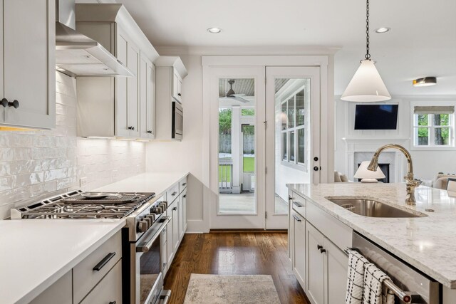 1547 Battlefield Dr, Nashville, TN 37215 - kitchen with stainless steel appliances, backsplash, a sink, a fireplace, and wall chimney exhaust hood