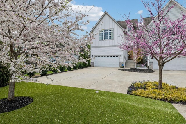 1547 Battlefield Dr, Nashville, TN 37215 - view of front of house featuring a front yard, board and batten siding, concrete driveway, and an attached garage