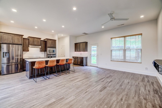 1006 Chisolm Trl, Goodlettsville, TN 37072 - kitchen with light countertops, stainless steel appliances, under cabinet range hood, a center island with sink, and light wood-style floors