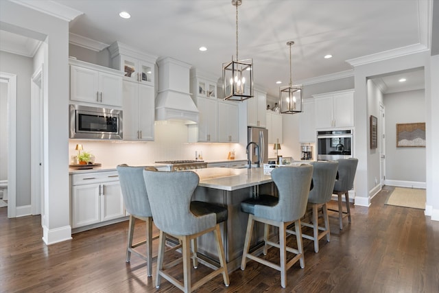 kitchen featuring stainless steel appliances, a kitchen breakfast bar, tasteful backsplash, white cabinets, and recessed lighting