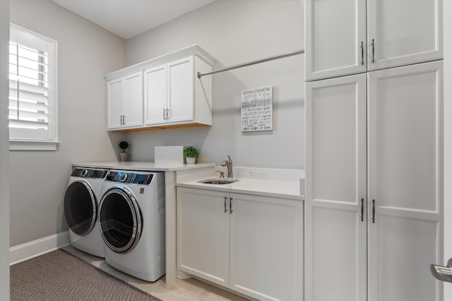 washroom with washer and dryer, cabinet space, and baseboards