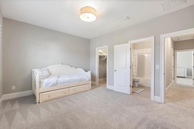 carpeted bedroom featuring a walk in closet, baseboards, connected bathroom, and a closet