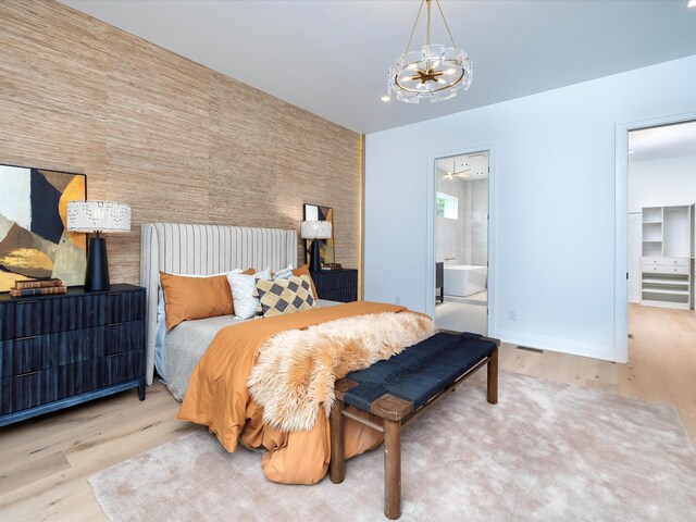 3848 Granny White Pike, Nashville, TN 37204 - bedroom featuring a chandelier, wood finished floors, an accent wall, baseboards, and a spacious closet