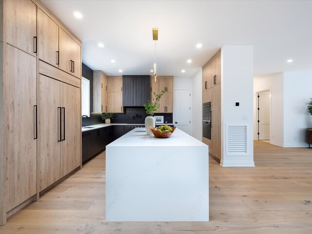 3848 Granny White Pike, Nashville, TN 37204 - kitchen with light brown cabinets, a kitchen island with sink, light wood finished floors, light countertops, and recessed lighting