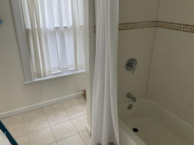 full bath with a wealth of natural light, shower / bathtub combination with curtain, tile patterned flooring, and baseboards