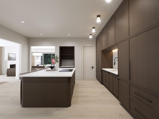 825B Kirkwood Ave, Nashville, TN 37204 - kitchen with a center island, open shelves, light countertops, dark brown cabinetry, and light wood finished floors
