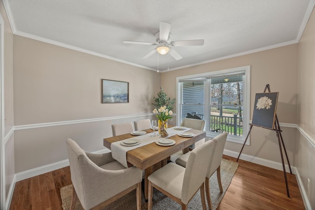 dining area featuring wood finished floors, ceiling fan, baseboards, and ornamental molding
