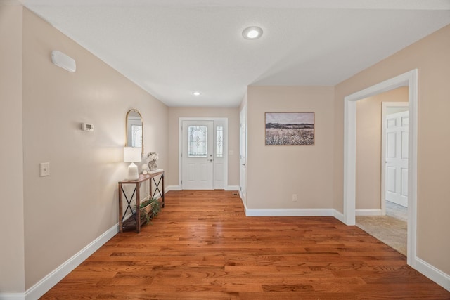 entryway featuring wood finished floors, baseboards, and recessed lighting