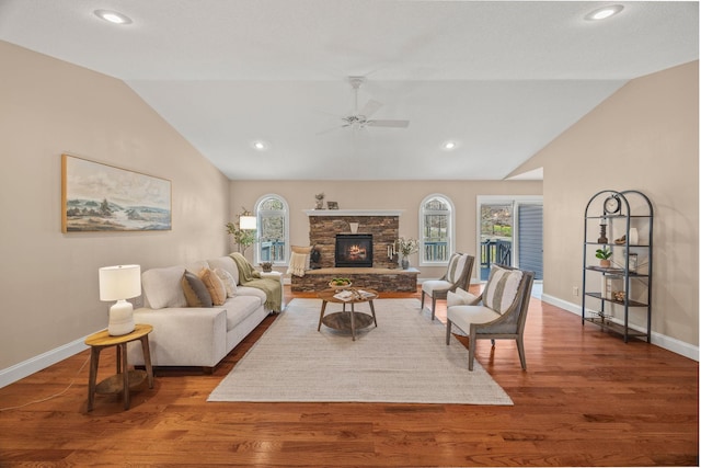 living room with a healthy amount of sunlight, baseboards, a ceiling fan, and lofted ceiling