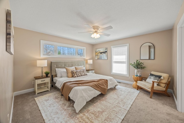 carpeted bedroom with ceiling fan, baseboards, and multiple windows