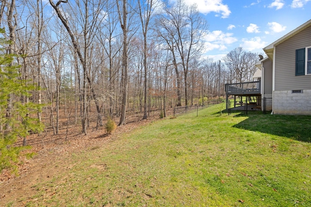 view of yard featuring fence, a deck, and stairway