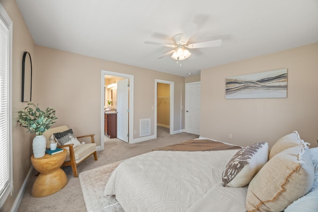 bedroom with visible vents, baseboards, a spacious closet, a ceiling fan, and light colored carpet