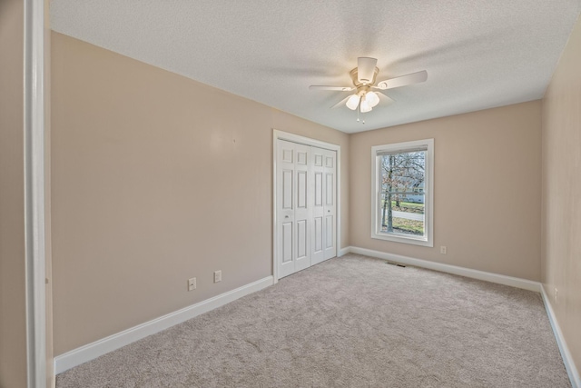unfurnished bedroom with carpet floors, baseboards, a closet, and a textured ceiling