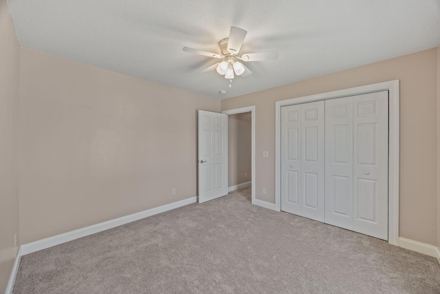unfurnished bedroom featuring a closet, baseboards, carpet flooring, and ceiling fan