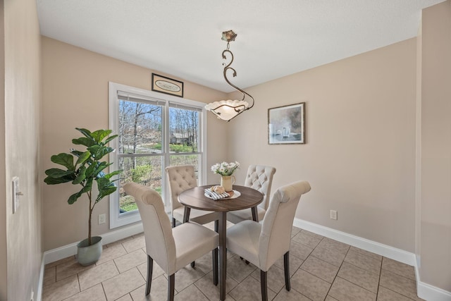 dining area featuring light tile patterned floors and baseboards