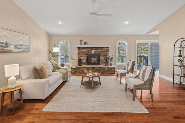 living area with wood finished floors, a ceiling fan, and vaulted ceiling