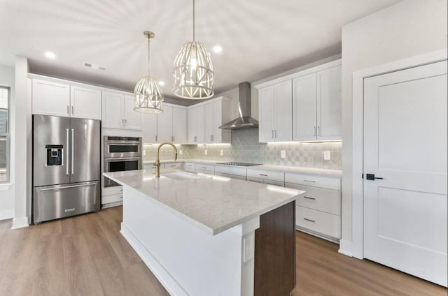 2615 Wilkinson Pike Unit 7A, Murfreesboro, TN 37129 - kitchen with appliances with stainless steel finishes, wall chimney range hood, wood finished floors, a chandelier, and tasteful backsplash
