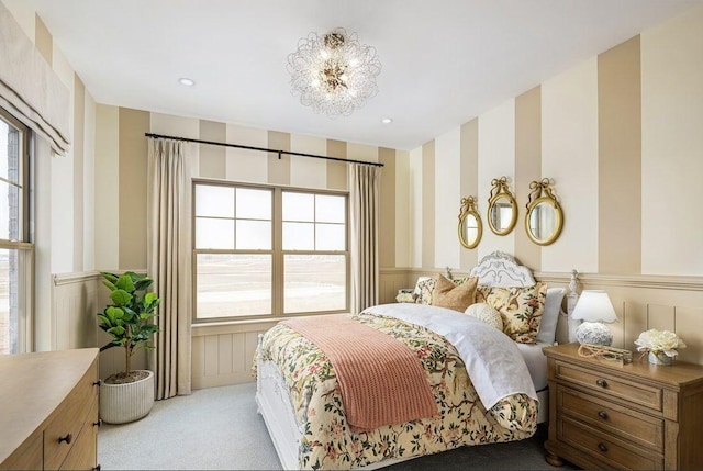 carpeted bedroom featuring a wainscoted wall, wallpapered walls, recessed lighting, and a chandelier