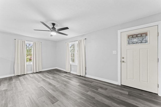 interior space featuring baseboards, wood finished floors, and a ceiling fan