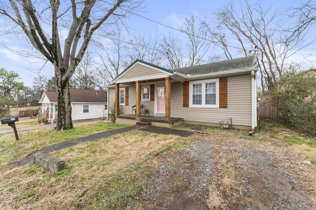 bungalow-style house featuring metal roof, fence, and a porch
