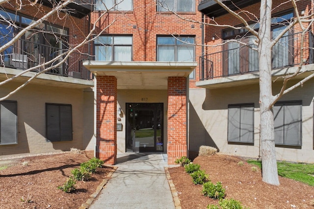 view of exterior entry featuring brick siding