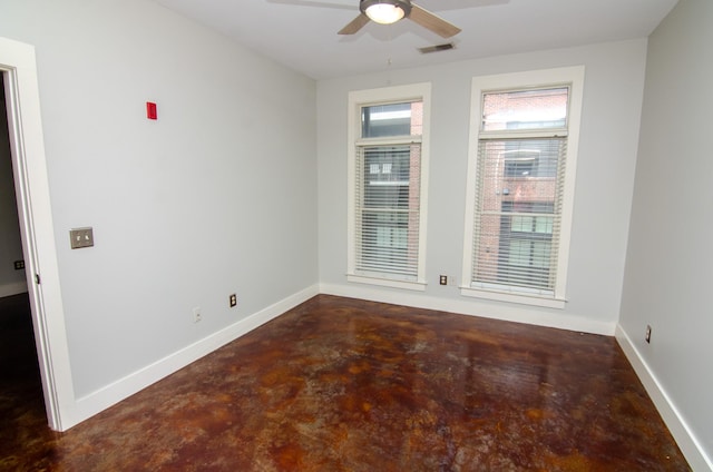 empty room featuring ceiling fan, finished concrete flooring, baseboards, and visible vents