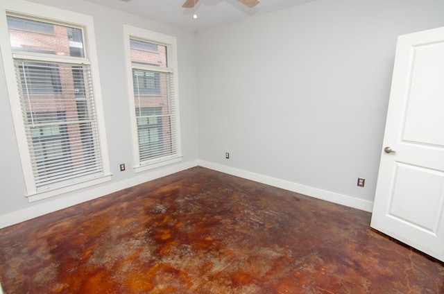 unfurnished room featuring concrete floors, baseboards, and a ceiling fan