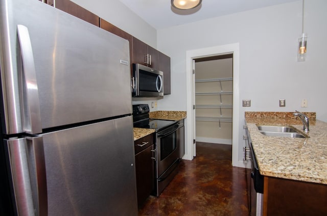 kitchen with baseboards, light stone counters, a sink, finished concrete floors, and appliances with stainless steel finishes
