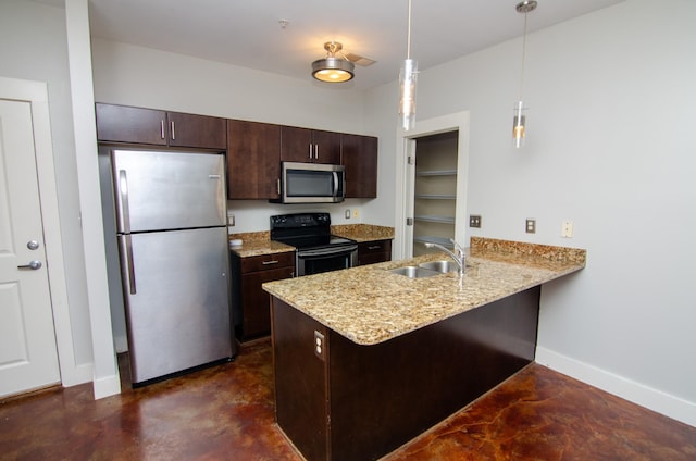 kitchen featuring baseboards, dark brown cabinets, a sink, a peninsula, and stainless steel appliances