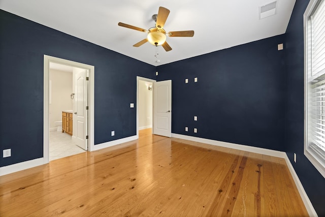 unfurnished bedroom featuring baseboards, visible vents, and wood finished floors