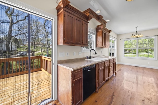 kitchen with light countertops, a chandelier, dishwasher, a sink, and light wood-style floors