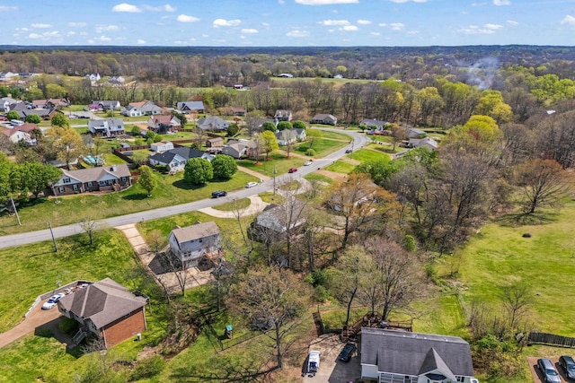 drone / aerial view featuring a residential view and a wooded view