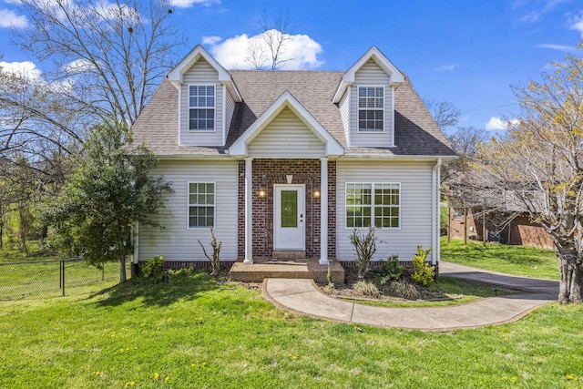 cape cod house with brick siding, a front yard, a shingled roof, and fence