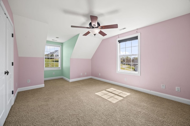 additional living space featuring vaulted ceiling, carpet floors, baseboards, visible vents, and ceiling fan