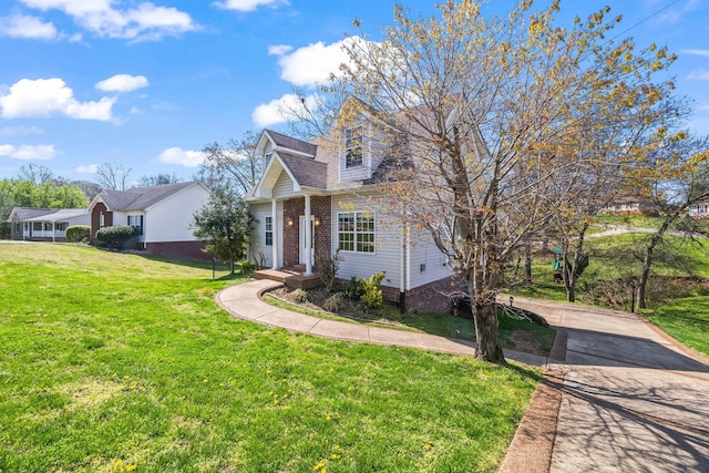view of front facade featuring brick siding, a front lawn, and concrete driveway