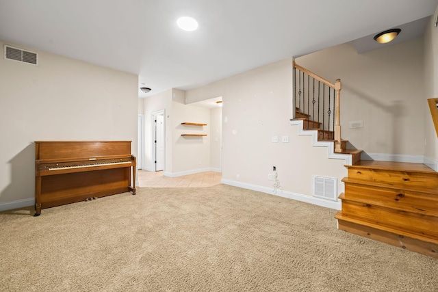 interior space with baseboards, carpet, stairway, and visible vents