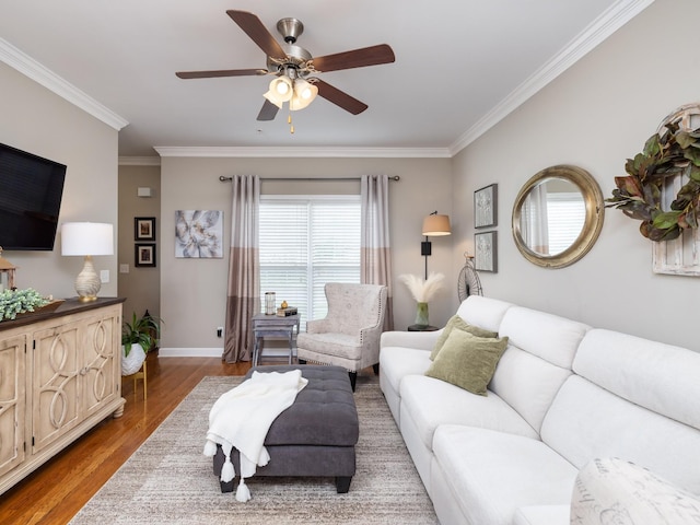 living area with ceiling fan, baseboards, ornamental molding, and wood finished floors