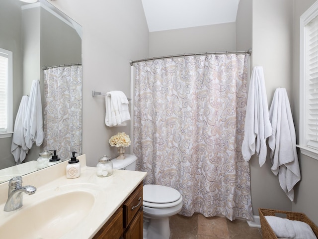bathroom featuring tile patterned flooring, toilet, plenty of natural light, and vanity
