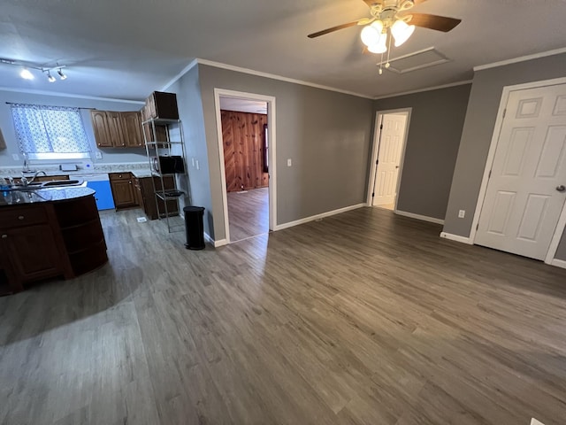 kitchen with dark wood finished floors, baseboards, ornamental molding, and dishwashing machine