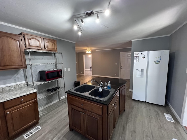 kitchen with visible vents, a sink, light wood-style floors, crown molding, and white refrigerator with ice dispenser