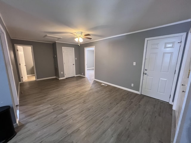 unfurnished living room with dark wood-style flooring, visible vents, baseboards, a ceiling fan, and crown molding