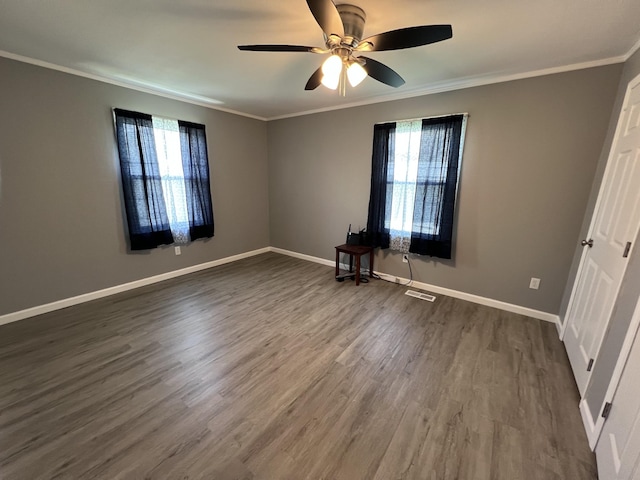 unfurnished bedroom featuring dark wood-style flooring, crown molding, baseboards, and multiple windows