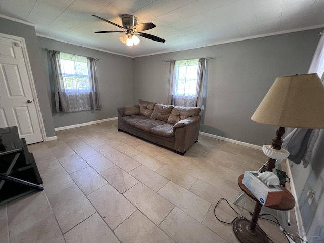 living area with ceiling fan, a wealth of natural light, and ornamental molding