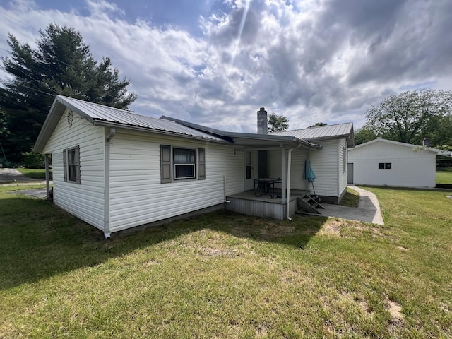 31 Marler St, Tracy City, TN 37387 - rear view of house with a chimney, metal roof, and a lawn